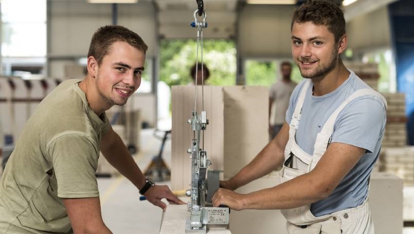 Zwei junge Männer arbeiten am Versetzkran