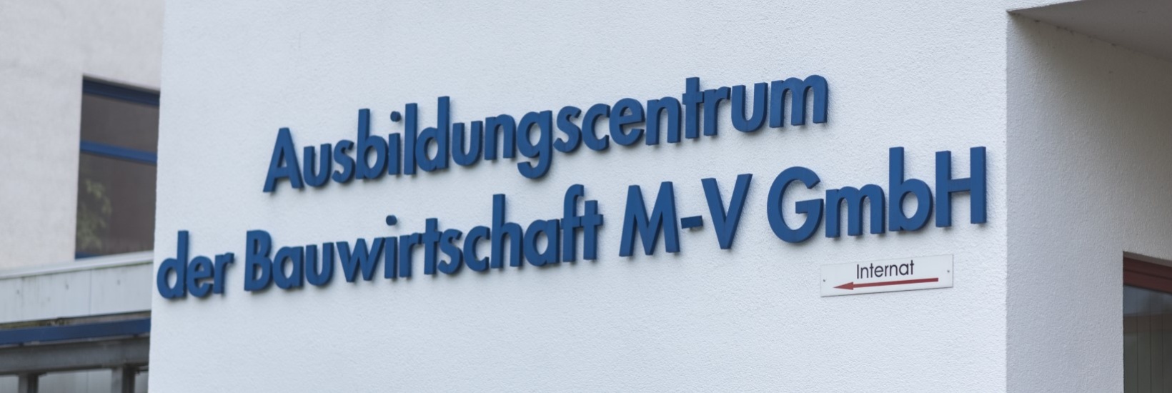 Schriftzug Ausbildungscentrum der Bauwirtschaft M-V GmbH an Hauswand